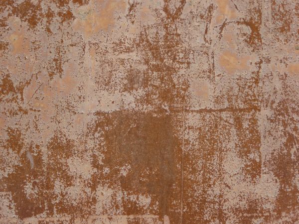 Tan metal texture, almost completely covered by a light, rough surface of dark red rust.